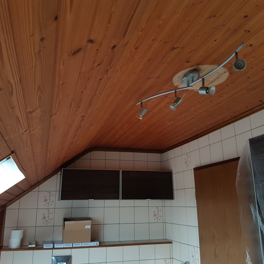 Urzustand des Badezimmers : Dunkle alte Holzdecke und unzureichende Beleuchtung durch einen Stromfressenden 4er Hallogenlampenbogen.